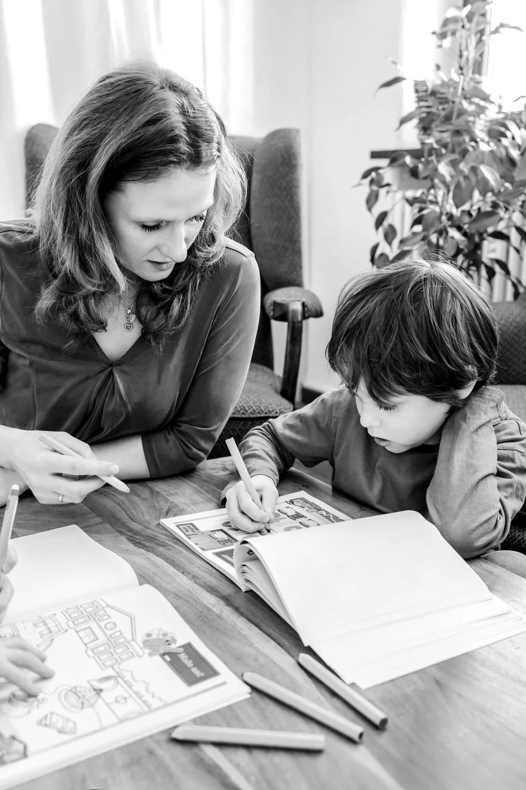 Mutter hilft Kind beim Lernen am Tisch